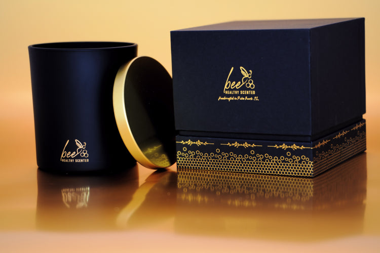 A black gift box and a Black luxury candle jar depicting the Bee Healthy Scented Logo and Honeycombs at the bottom